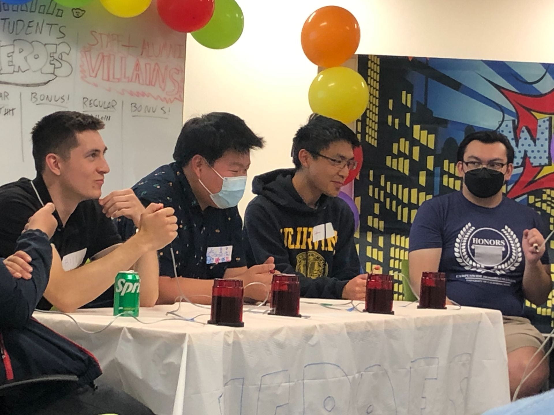 four male honors students sit at a table for annual trivia competition